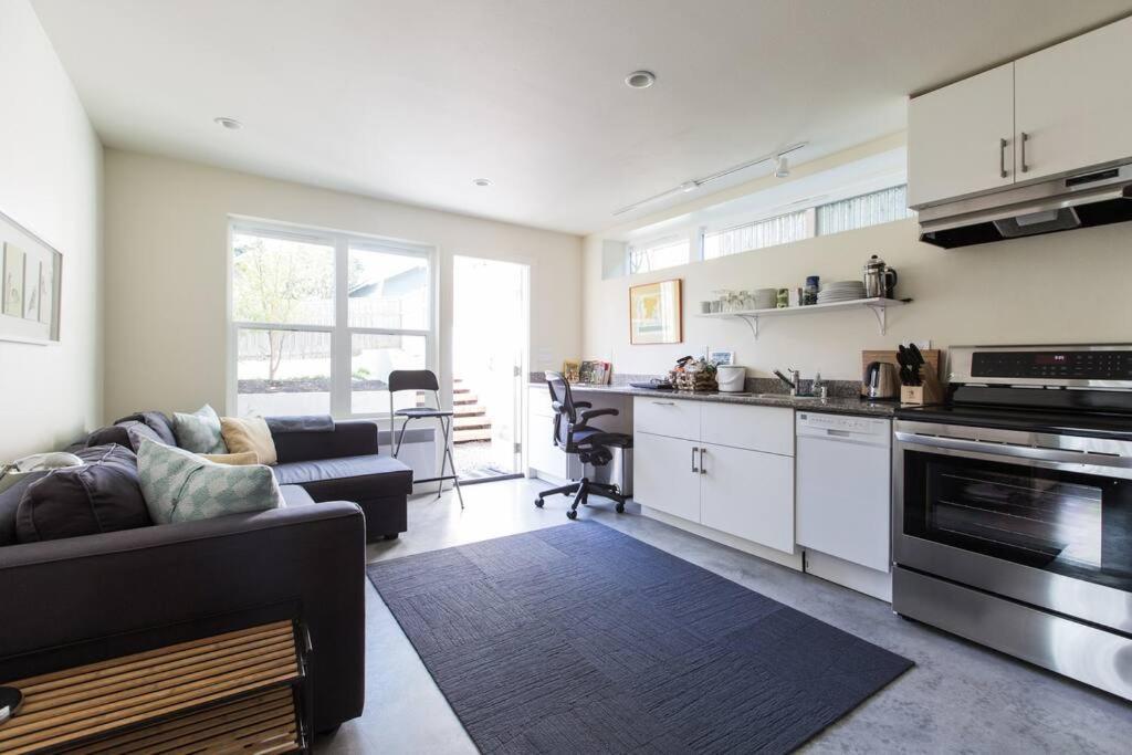 een woonkamer met een bank en een keuken bij LEED Platinum Green Home Getaway in Seattle