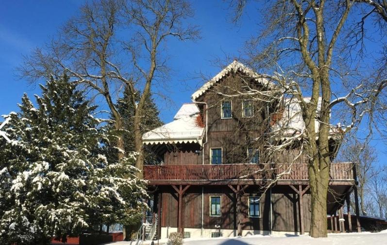 ein großes Backsteinhaus mit Schnee auf dem Boden in der Unterkunft Dambachhaus Thale in Thale