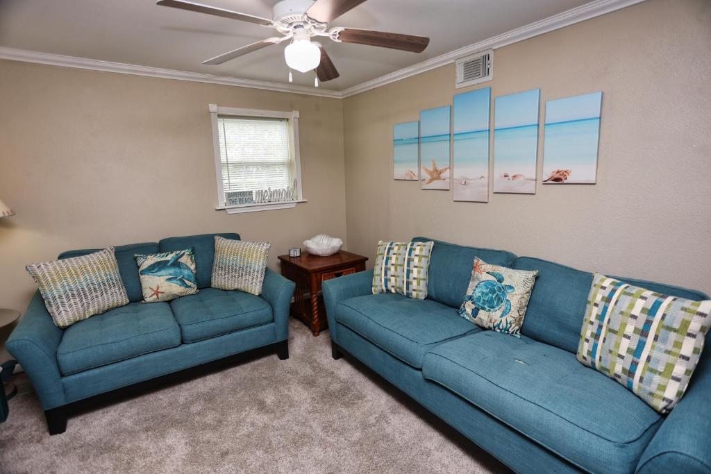 salon z 2 niebieskimi sofami i wentylatorem sufitowym w obiekcie Quick & Intimate Beach Getaway w mieście Galveston