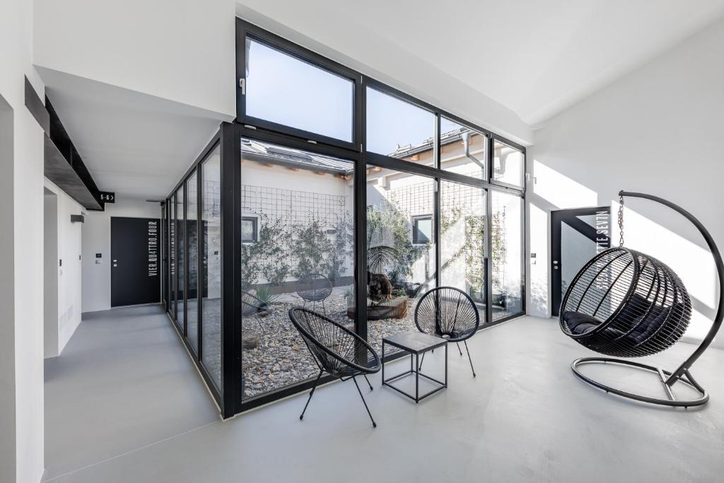 a room with two chairs and large windows at Stay COOPER l CITY LOFT in Bolzano