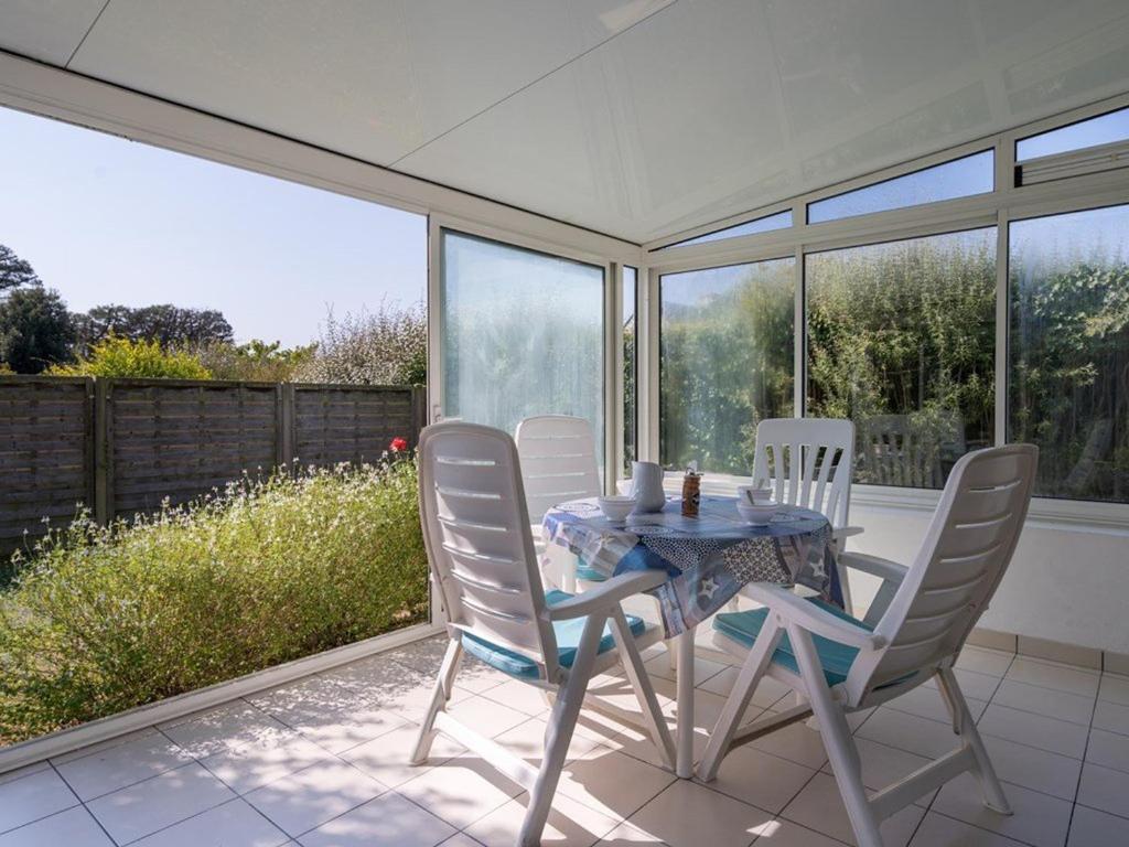 a dining room with a table and chairs on a patio at Villa Locmariaquer, 3 pièces, 4 personnes - FR-1-477-36 in Locmariaquer