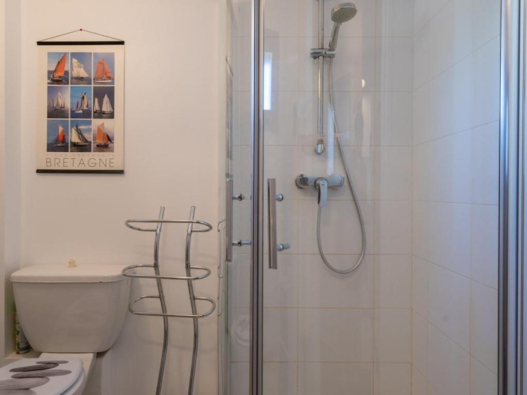 a bathroom with a shower with a toilet and a glass shower at Villa Locmariaquer, 3 pièces, 4 personnes - FR-1-477-36 in Locmariaquer