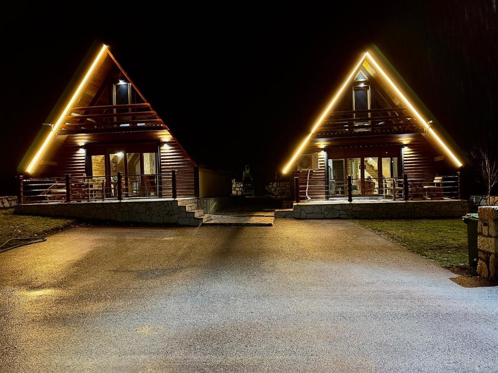 a house with lights on the front of it at night at Mountain Villas Žabljak in Žabljak