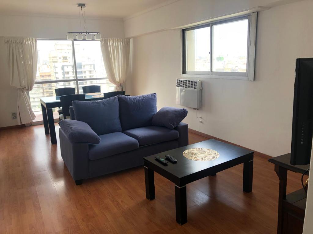 sala de estar con sofá azul y mesa en Diagonal depto 3 ambientes zona centro en Mar del Plata