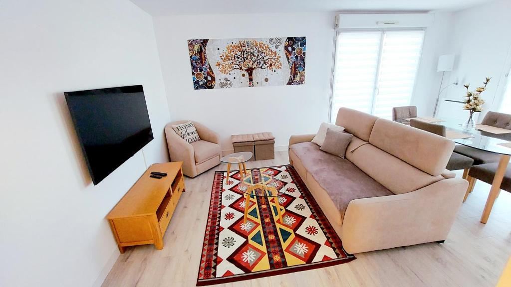 a living room with a couch and a tv at Cosy Home 1, Cergy Le Haut, 6 personnes, 3 min gare, 30 min Paris, parking privé in Cergy