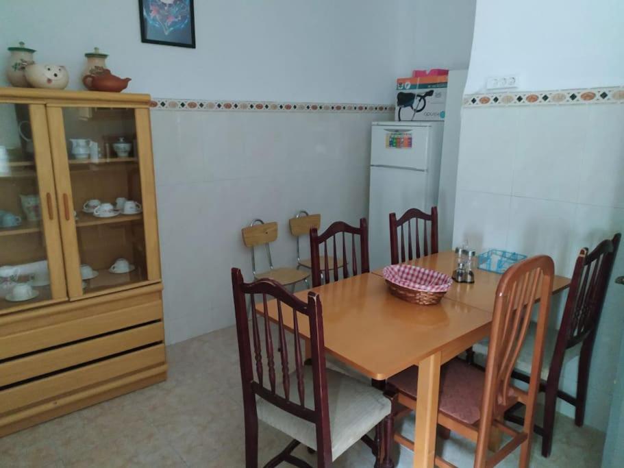 a kitchen with a table and chairs and a refrigerator at Amplio piso en centro con balcón in Cuenca