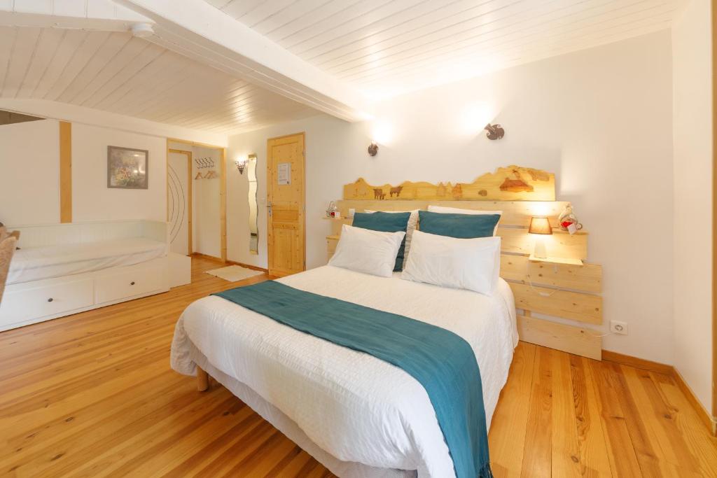 a bedroom with a large white bed with blue pillows at Le Fournia in Grandrif