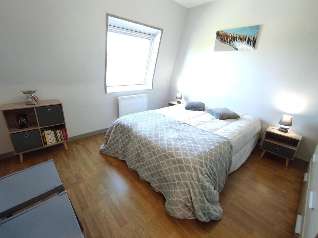une chambre avec un lit et une fenêtre dans l'établissement Appartement rénové, calme 300m plage, avec parking et balcon – Beg Meil, Fouesnant - FR-1-481-55, à Fouesnant