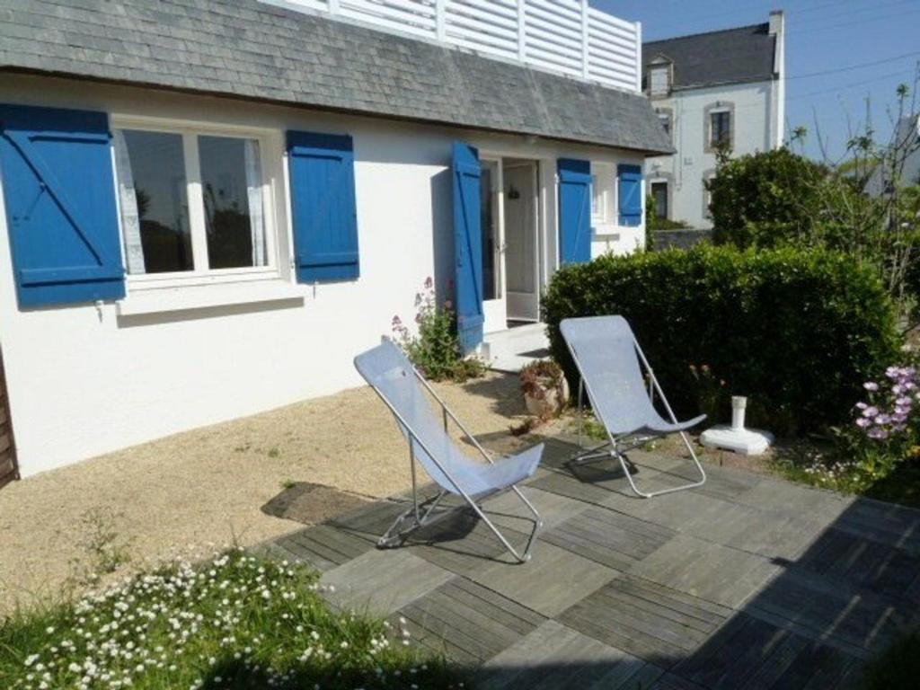2 chaises et un chien assis sur une terrasse dans l'établissement Charmante maison 2 pièces, 4 pers, plage à pied, quartier calme, jardin, Wi-Fi, animaux ok, parking - FR-1-478-171, à Quiberon