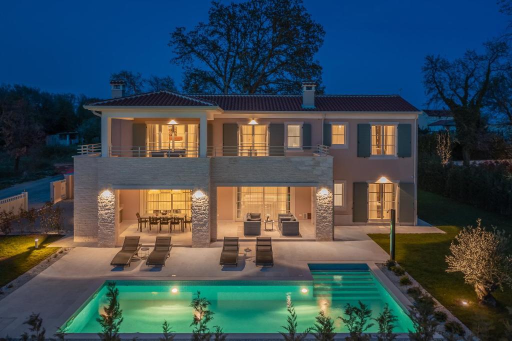 a house with a swimming pool at night at Villa Estelle by ILC (Istria Luxury Collection) in Brtonigla