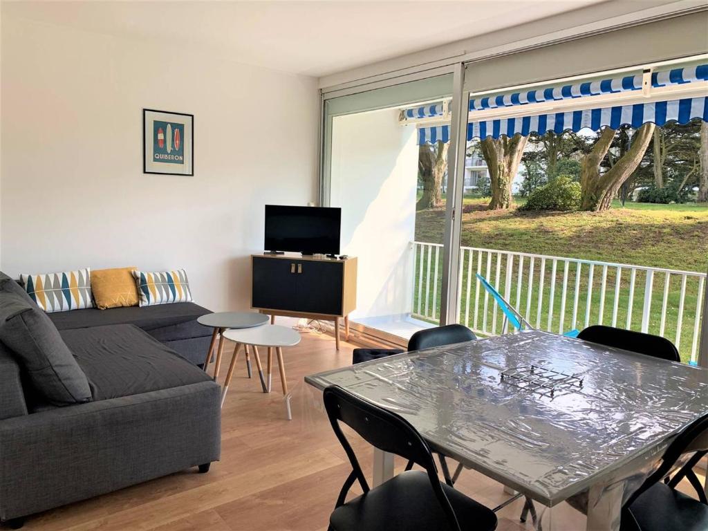 een woonkamer met een bank en een tafel met stoelen bij Appartement Quiberon, 2 pièces, 3 personnes - FR-1-478-182 in Quiberon
