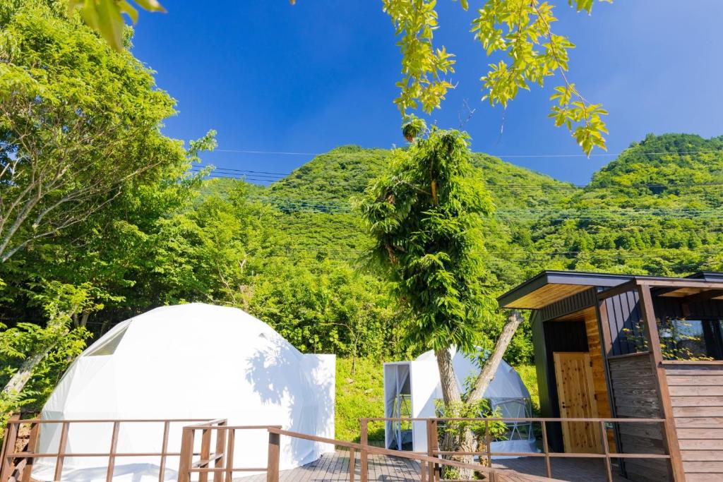 湯布院的住宿－The Village Yufuin Onsen Glamping - Vacation STAY 18006v，白色圆顶帐篷,背景为山脉