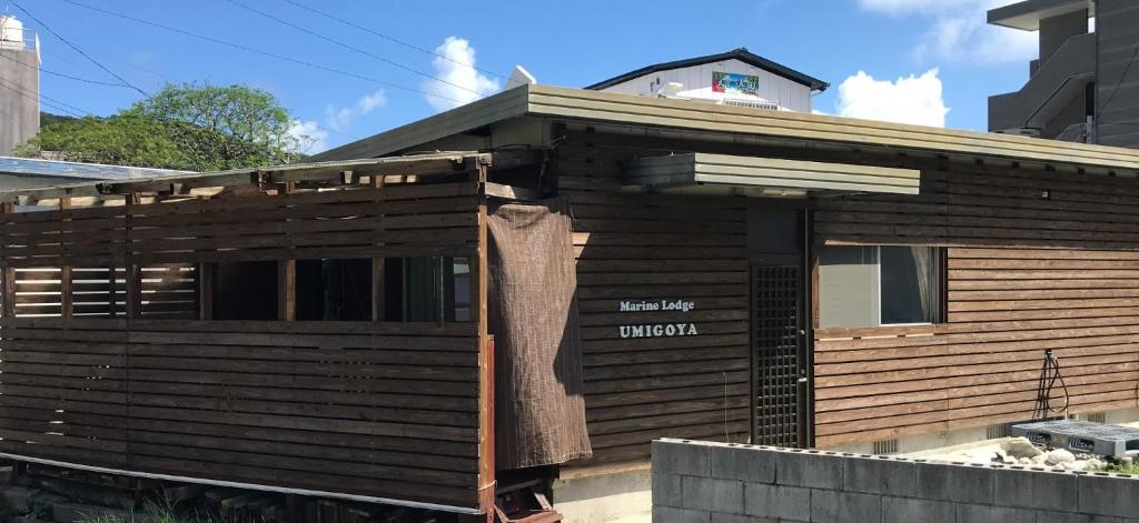 una casa in legno con un cartello sopra di Marine Lodge Umigoya - Vacation STAY 23086v a Zamami