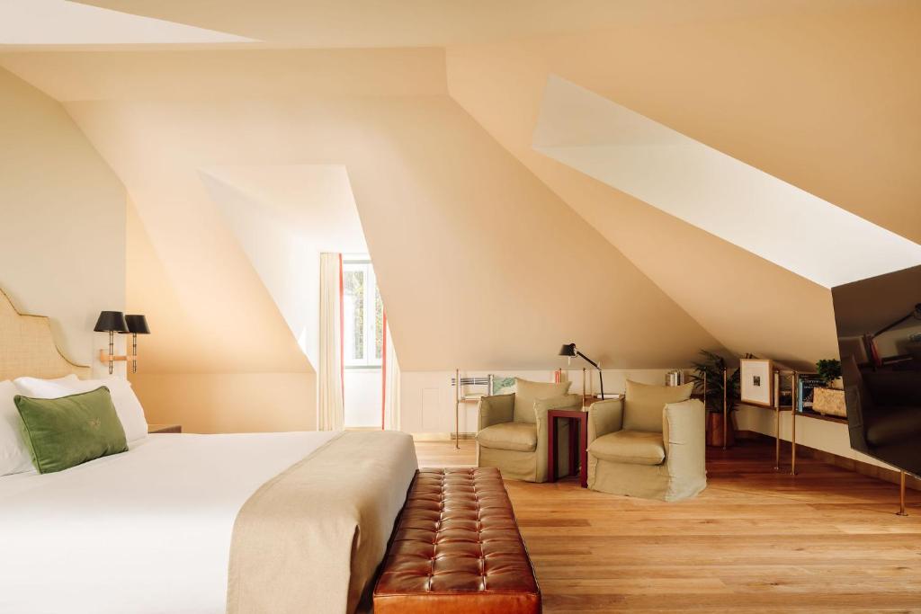 An airy sloped-ceiling bedroom opens into a separate sitting area.