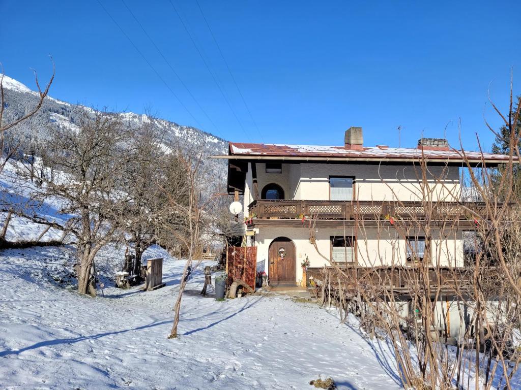 a house in the snow with a mountain in the background at Ferienhaus Gastein in Bad Hofgastein