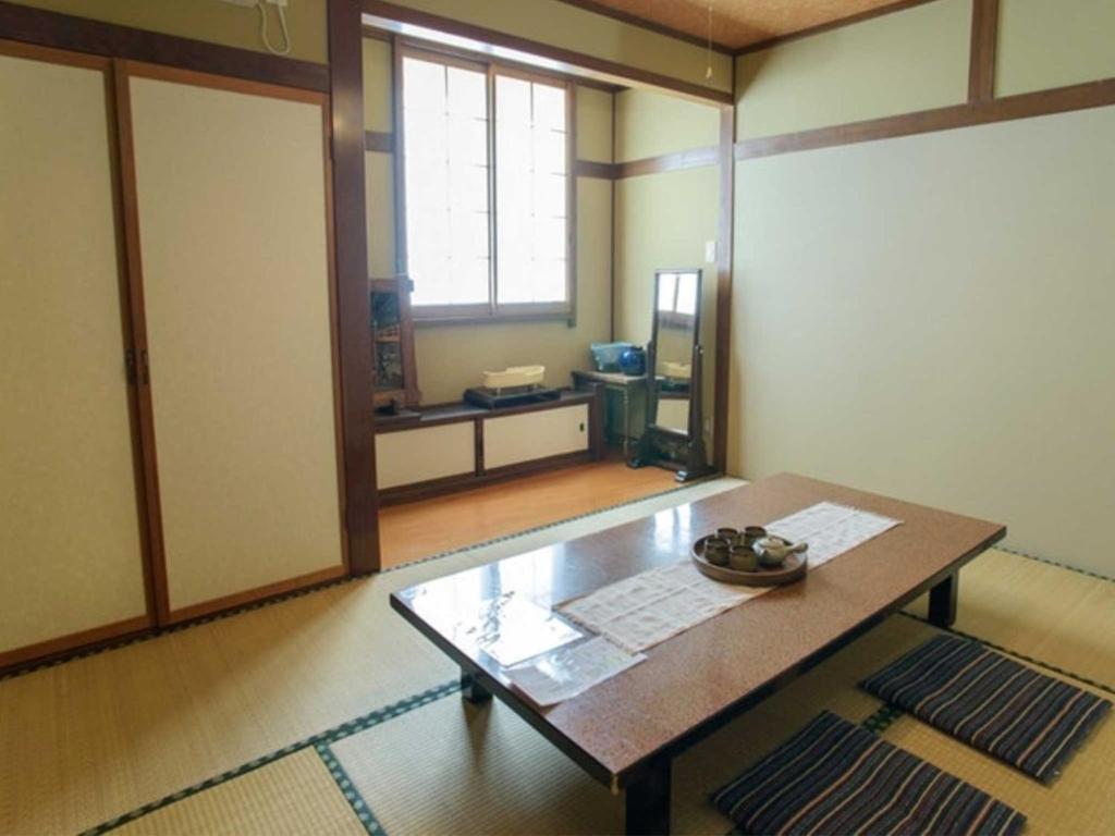 um quarto com uma mesa de madeira e uma janela em Guest houseTakagi - Vacation STAY 59918v em Matsumoto