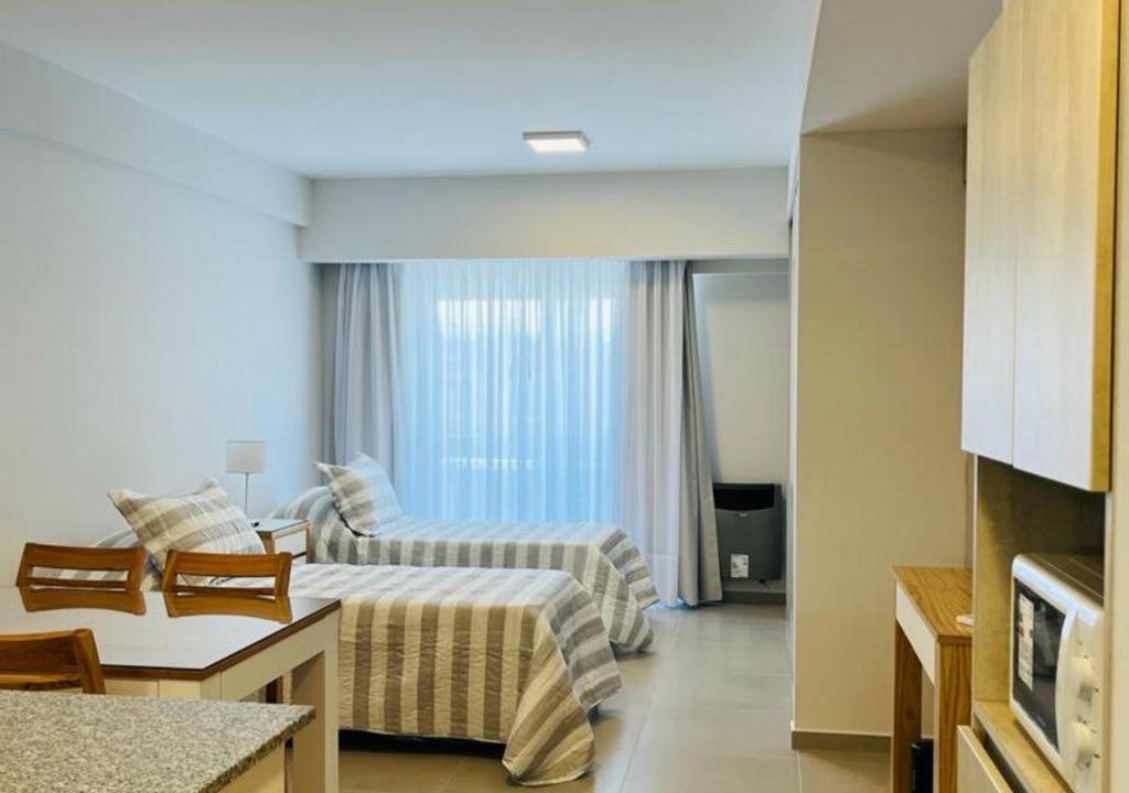 a hotel room with two beds and a kitchen at Monoambiente Calle 11 in La Plata