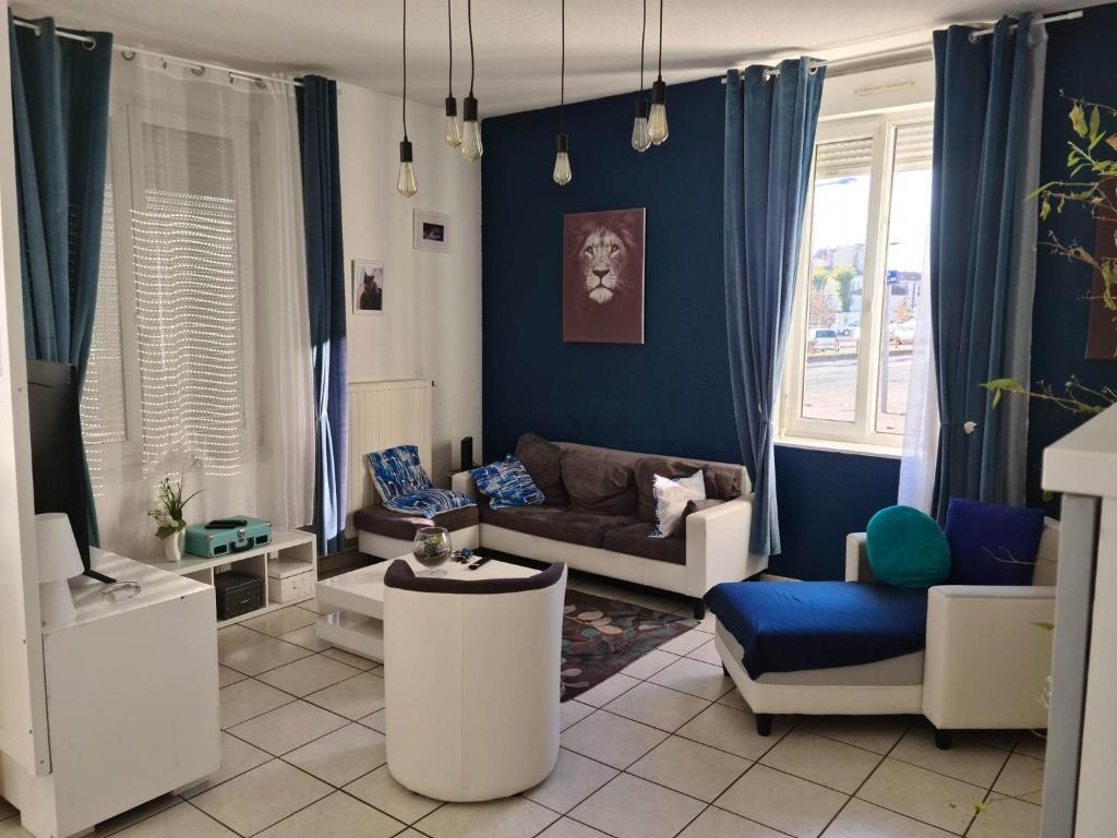 een woonkamer met blauwe muren en witte meubels bij Ma petite escale in Romans-sur-Isère