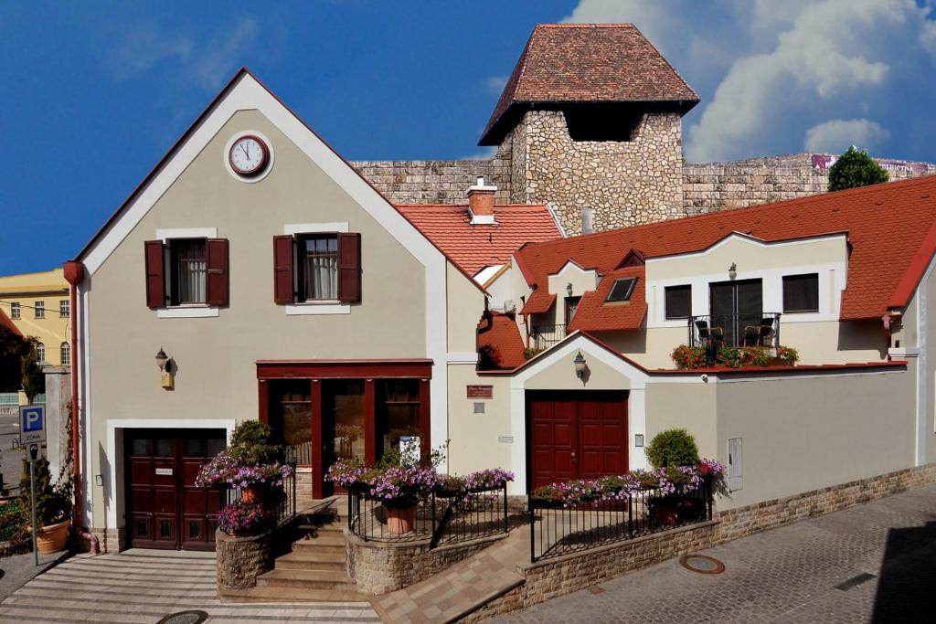 a white house with a clock on top of it at Pátria Panzió in Eger