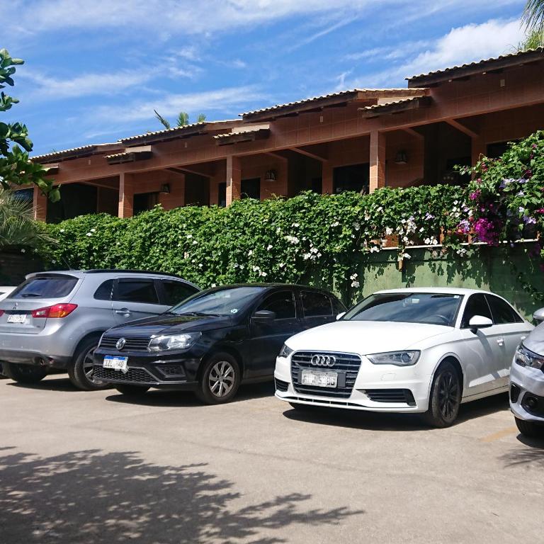 un grupo de autos estacionados en un estacionamiento en Pousada Suites do Santinho, en Florianópolis