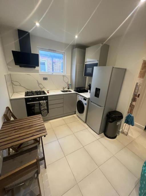 a kitchen with a stove and a refrigerator at Chester road,N17,Bright Studio in London