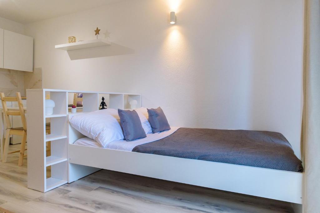a bedroom with a white bed with a white shelf at Donata Apartments Zadar in Zadar
