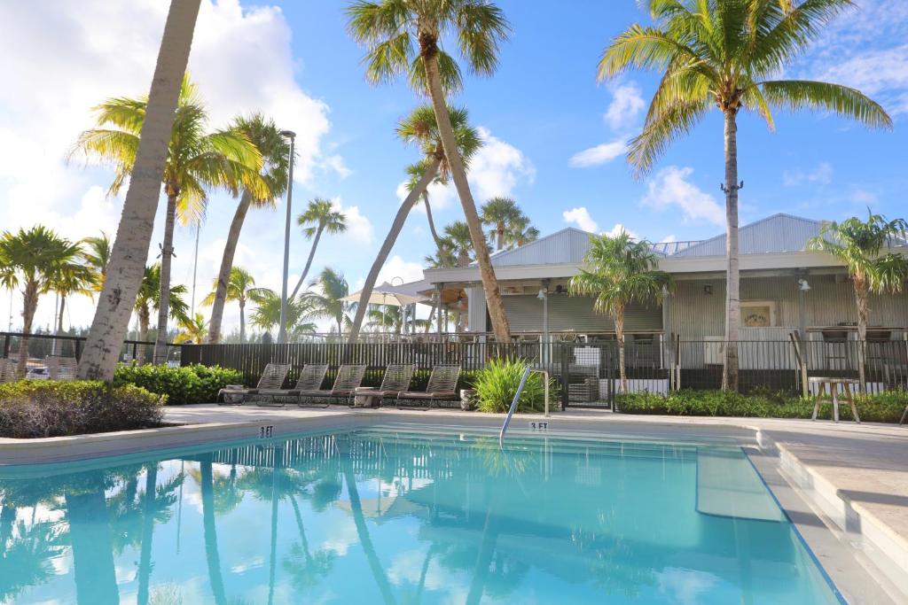 a swimming pool in front of a house with palm trees at The Perry Hotel & Marina Key West in Key West