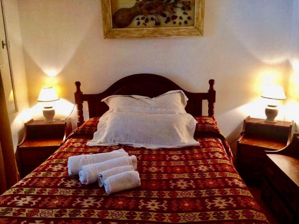 1 dormitorio con 1 cama con 2 toallas en Departamento Pama en Santa Rosa de Calamuchita