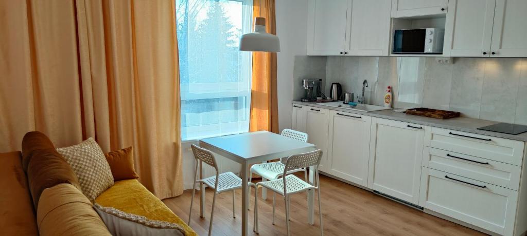 uma cozinha com um sofá e uma mesa numa cozinha em Młynarska - słoneczne apartamenty em Piaseczno