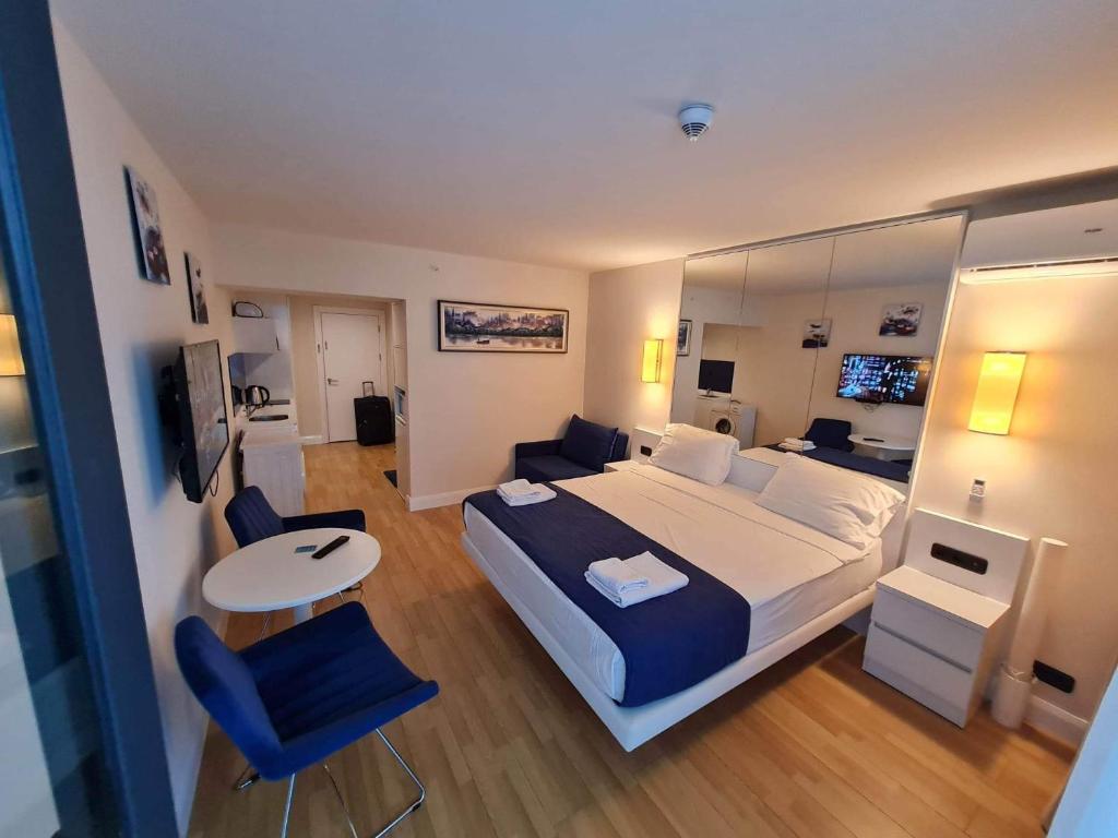 1 dormitorio con 1 cama grande, mesa y sillas en Orbi City Batumi en Batumi