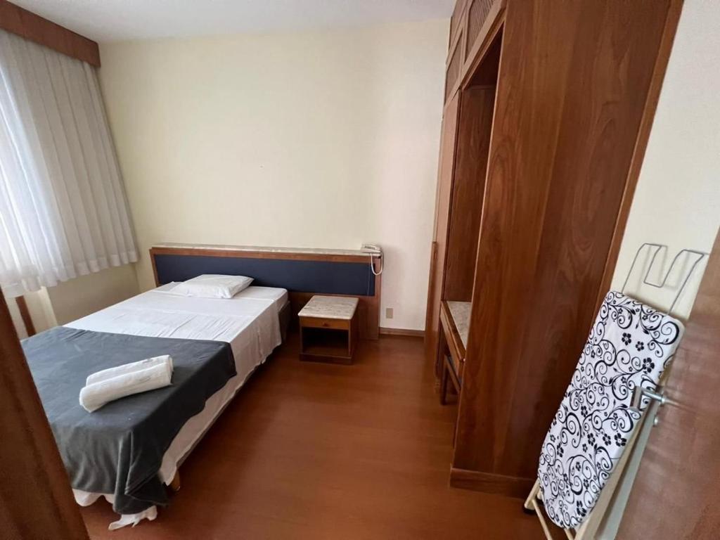 een kleine slaapkamer met een bed en een houten vloer bij Locking's Funcionários 4 in Belo Horizonte