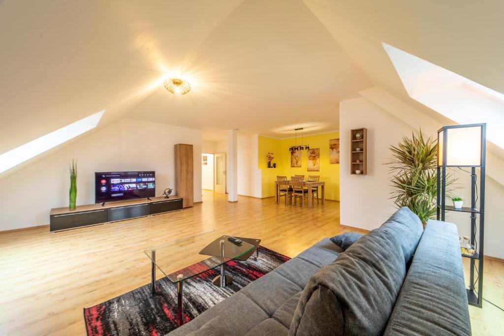 sala de estar con sofá y TV en Moderne Dachgeschosswohnung - Parkplatz - Netflix en Coburg