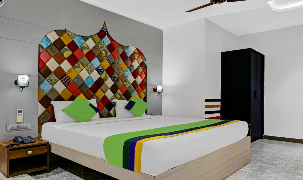 um quarto com uma cama grande e uma cabeceira colorida em Itsy By Treebo - Banana Boutique Varuna Bridge Varanasi em Varanasi