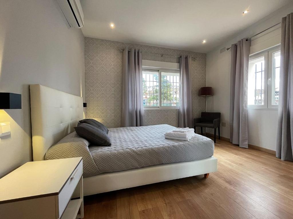 a bedroom with a bed and a desk and windows at Apartamentos Ronda Luz in Ronda