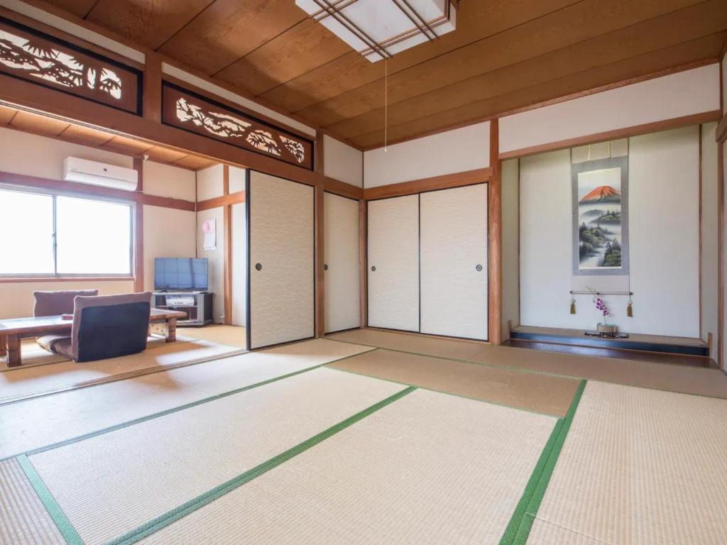Habitación vacía con puertas, mesa y sofá en Minpaku Yamamoto - Vacation STAY 13868 en Izumiotsu
