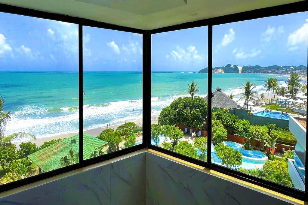 a room with a view of the beach and ocean at Atlântico Flat in Natal