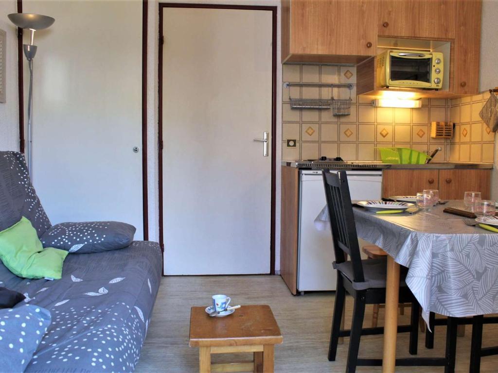 a living room with a couch and a table and a kitchen at Appartement Risoul, 1 pièce, 4 personnes - FR-1-330-61 in Risoul