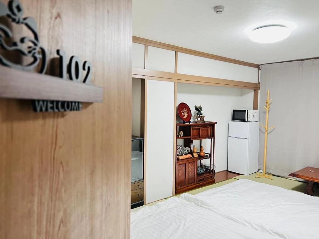 a bedroom with a bed and a kitchen with a microwave at FUKUINN - Vacation STAY 19245v in Takamatsu