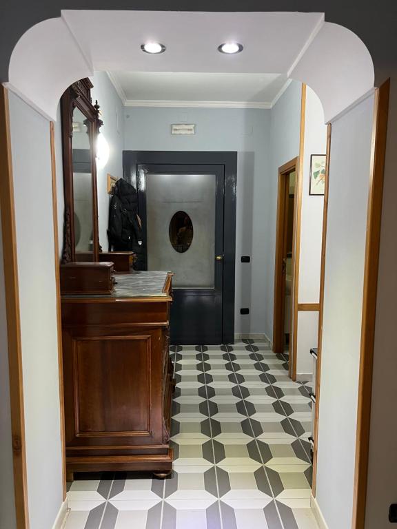 a hallway with a mirror and a piano on a checkered floor at Bell'e Buono vicino aeroporto di Capodichino in Naples
