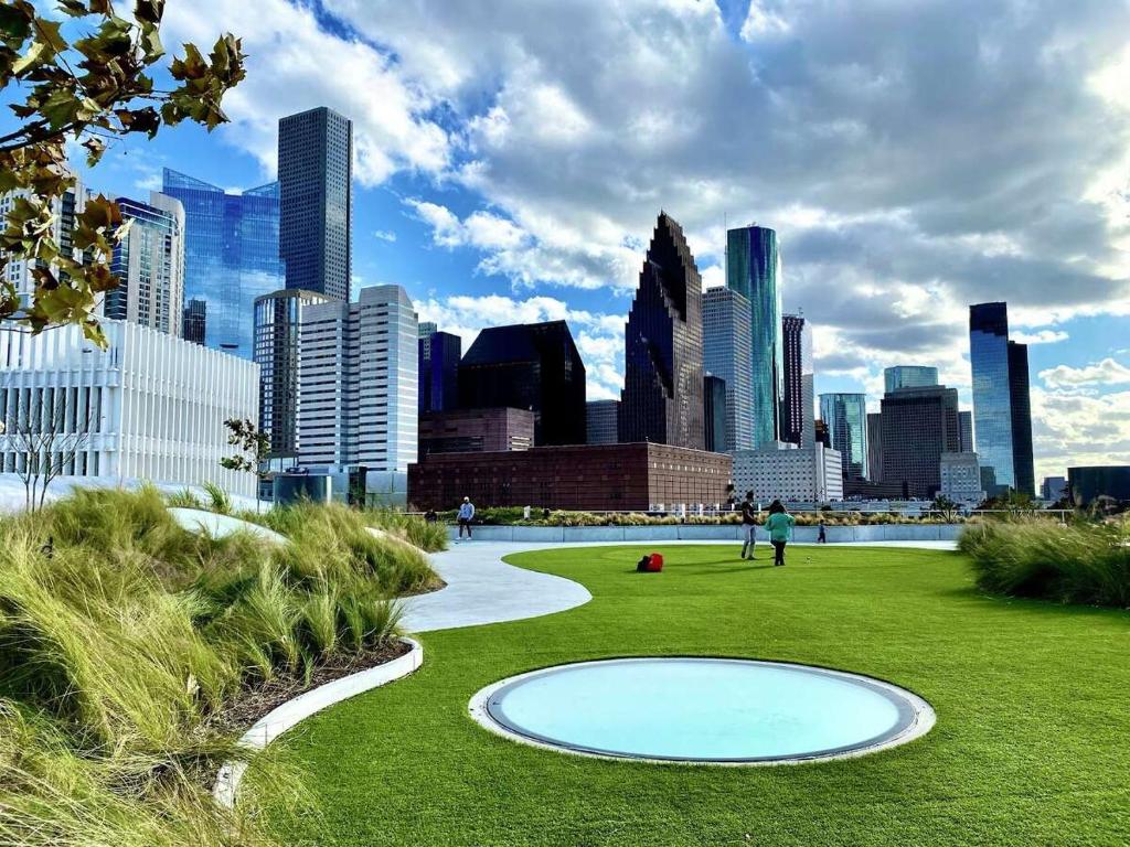 a park with a city skyline in the background at Modern Downtown Houston Your Home Base for City Adventures! in Houston