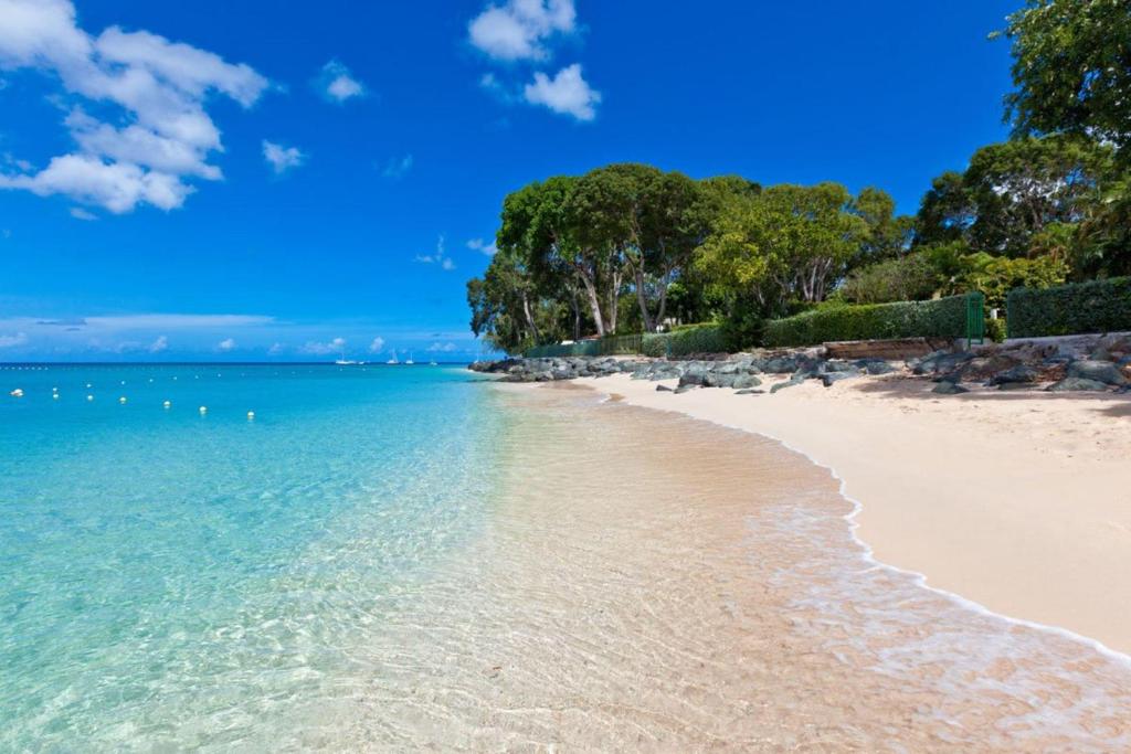 een strand met blauw water en bomen op de achtergrond bij Church Point 2 by Blue Sky Luxury in Saint James