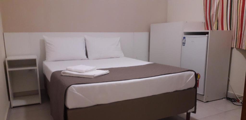a bedroom with a bed with two towels on it at BH EXPO SUITES & KITNETES in Belo Horizonte