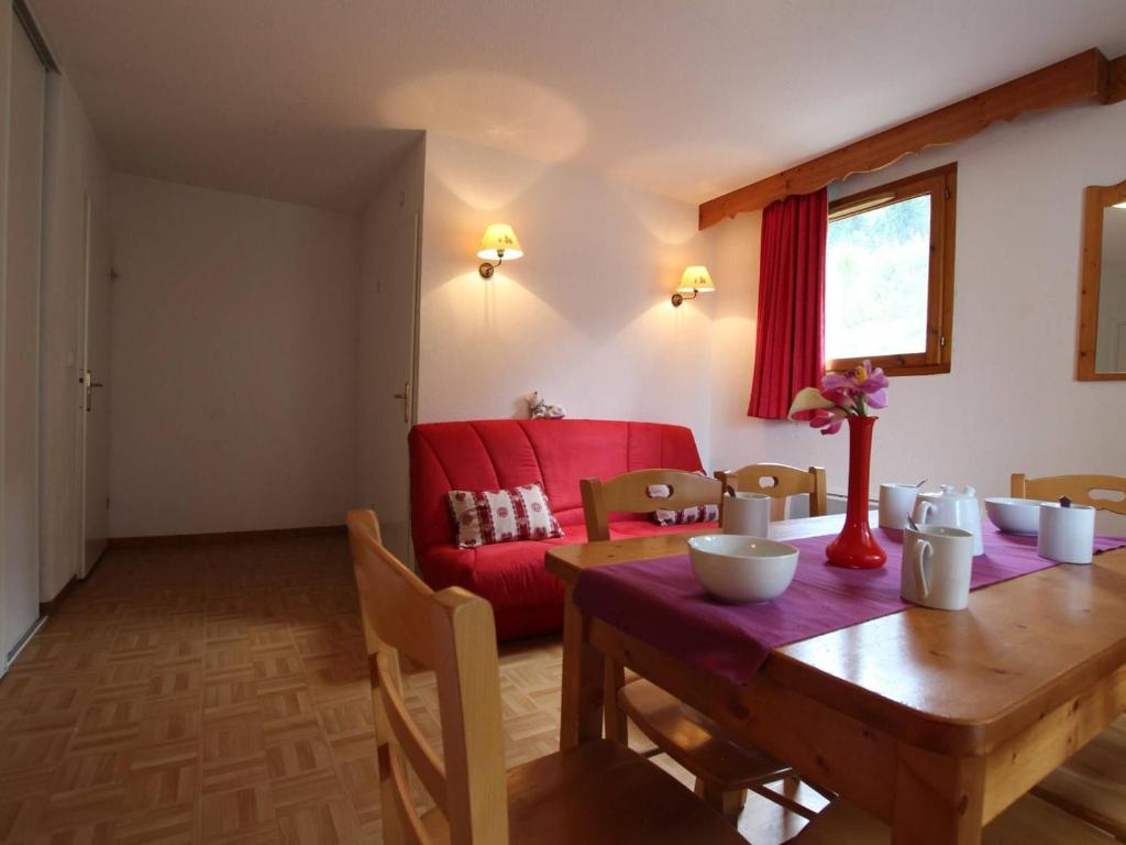 sala de estar con mesa y sofá rojo en Appartement Puy-Saint-Vincent, 2 pièces, 6 personnes - FR-1-330G-80 en Puy-Saint-Vincent
