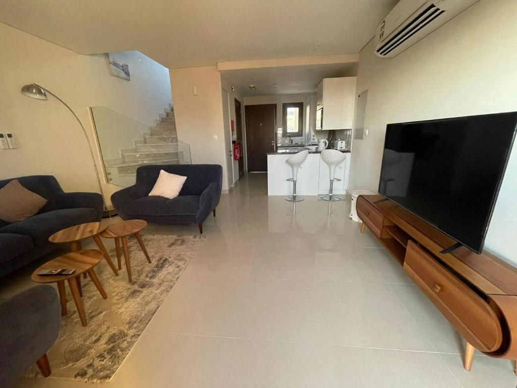 TV a/nebo společenská místnost v ubytování Sifa Beachfront Apartment