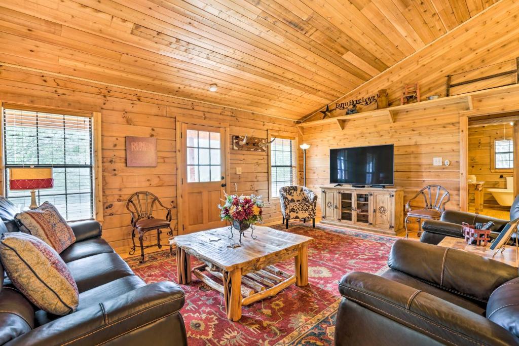 a living room with couches and a coffee table at Cozy New Braunfels Family Cabin with Porch and Views! in New Braunfels