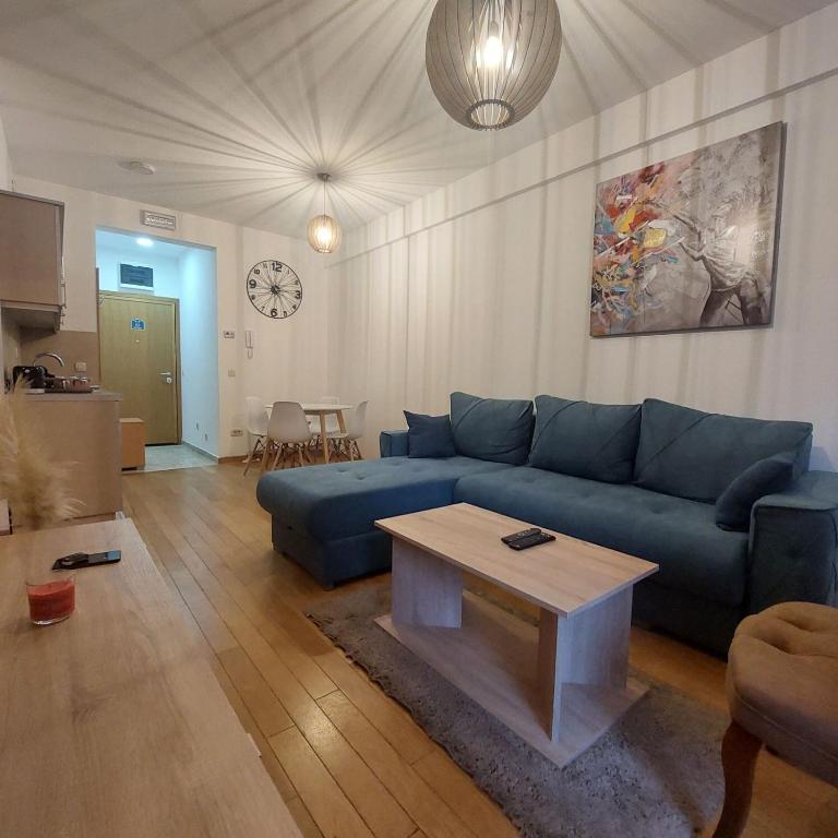 a living room with a blue couch and a table at Apartman Ana Alibi 1 in Zlatibor