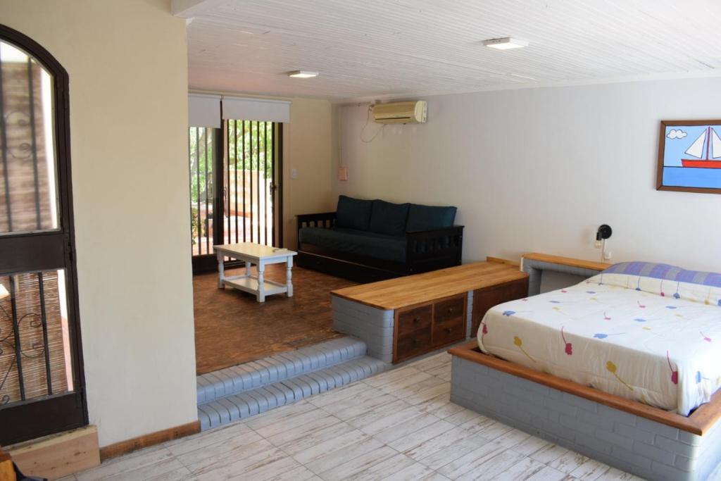 1 dormitorio con 1 cama y 1 sofá en Solaire Carrodilla en Luján de Cuyo