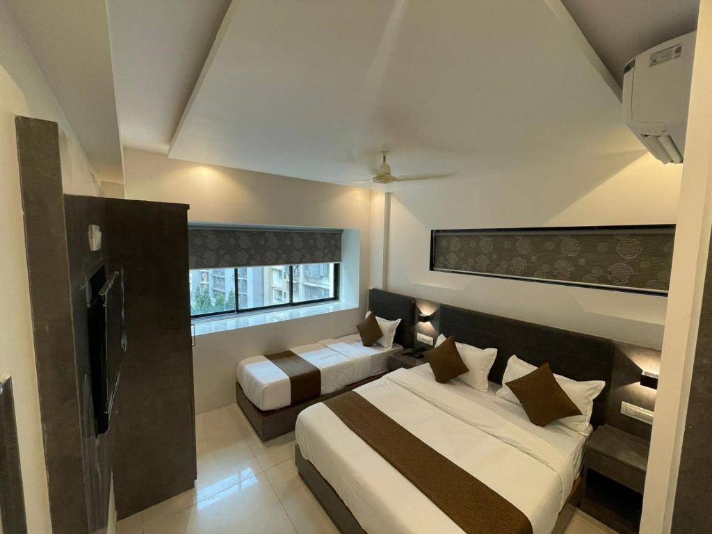 um quarto de hotel com duas camas e uma janela em Hotel lime wood em Mumbai
