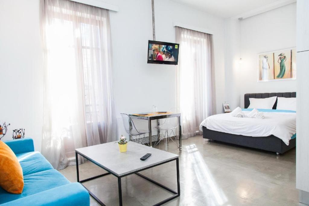 - une chambre avec un lit, un canapé et une table dans l'établissement Aθens Dome - Apartments by Live&Travel, à Athènes