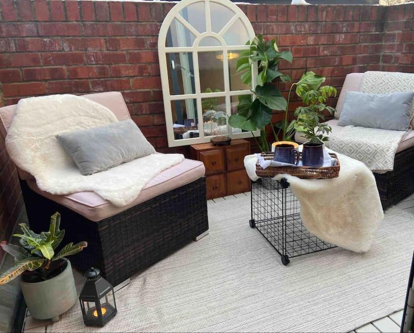um pátio com duas cadeiras, uma janela e plantas em Spitalfields Market Penthouse Flat with balcony em Londres